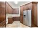 This pantry has beautiful wood cabinetry, a stainless steel fridge, and stone floors at 10537 N Crestview Dr, Fountain Hills, AZ 85268