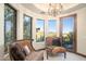 A well-lit sitting area features a chandelier, comfortable chairs, and views of the surrounding landscape at 10537 N Crestview Dr, Fountain Hills, AZ 85268