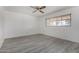 This bedroom features wood-look floors, a ceiling fan, and a window offering natural light at 4729 W Orangewood Ave, Glendale, AZ 85301