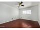 This bedroom features wood-look floors, a ceiling fan, and a window offering neighborhood views at 4729 W Orangewood Ave, Glendale, AZ 85301