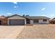 Charming single-story home with desert landscaping, gray garage door and white brick at 4729 W Orangewood Ave, Glendale, AZ 85301