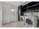 The laundry room features a side-by-side washer and dryer with a black cabinet and shelves at 4729 W Orangewood Ave, Glendale, AZ 85301