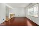 Bright, airy living room with wood floors, white walls, and natural light from a large window at 4729 W Orangewood Ave, Glendale, AZ 85301