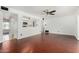Spacious living room with hardwood floors, a ceiling fan, and an open view to the kitchen at 4729 W Orangewood Ave, Glendale, AZ 85301