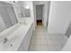 Spacious bathroom with a double sink vanity, tile floors, and a doorway to a walk-in closet at 16186 W Silver Falls Dr, Surprise, AZ 85374