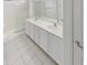 Bright bathroom featuring a double vanity with white cabinetry, tile flooring, and a glass-enclosed shower at 16186 W Silver Falls Dr, Surprise, AZ 85374
