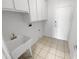 Functional laundry room with storage cabinets and utility sink at 16186 W Silver Falls Dr, Surprise, AZ 85374