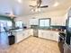 Bright and airy kitchen with white cabinets and tile floors at 10826 W Piute Ave, Sun City, AZ 85373