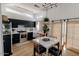Modern kitchen featuring black cabinets, stainless steel appliances, and a marble dining table at 11322 W Diana Ave, Peoria, AZ 85345