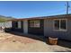 Side exterior of a grey house with a dirt and gravel yard with mountain views in the background at 1535 E Christy Dr, Phoenix, AZ 85020