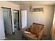 Interior view of a living room with a chair, open doorways and debris scattered around at 1535 E Christy Dr, Phoenix, AZ 85020