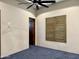 An empty bedroom with a ceiling fan and a window with brown shutters and a dark wooden door at 4327 E Capricorn Pl, Chandler, AZ 85249