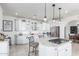 Open kitchen with white cabinets, granite island, and glass-front cabinets at 31221 N 161St Pl, Scottsdale, AZ 85262