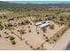 Aerial view of a desert property with a house and outbuildings at 192 S Ralston Rd, Maricopa, AZ 85139