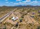 Aerial view of a desert property with a house and several outbuildings at 192 S Ralston Rd, Maricopa, AZ 85139