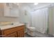Clean bathroom with wood vanity, shower, and white toilet at 192 S Ralston Rd, Maricopa, AZ 85139