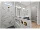 Luxurious bathroom showcasing a marble shower, double vanity, gold hardware, and contemporary design at 32480 N 134Th Ln, Peoria, AZ 85383