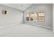 Bright bedroom featuring neutral carpet, large windows offering natural light, and a minimalist design at 32480 N 134Th Ln, Peoria, AZ 85383