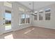 Bright dining area with wood-style flooring, a modern light fixture, and large windows offering backyard views at 32527 N 135Th Dr, Peoria, AZ 85383