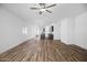 Open-concept living room with wood floors, ceiling fan, and kitchen access, perfect for entertaining at 24567 W Alta Vista Rd, Buckeye, AZ 85326