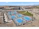 Aerial view of multiple outdoor pickleball courts with blue playing surfaces and surrounding landscaping at 37535 W Padilla St, Maricopa, AZ 85138