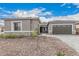 Home's exterior with stone accents, a well-manicured yard, and a two-car garage at 4735 W Stargazer Pl, Laveen, AZ 85339