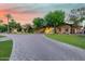 Sprawling estate featuring a circular driveway and mature trees under a vibrant sunset at 3831 E Huber St, Mesa, AZ 85205