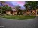 Beautiful home featuring verdant landscaping, a stone entryway, and elegant lighting at 3831 E Huber St, Mesa, AZ 85205
