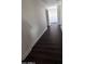 Long hallway with dark wood-look floors and white baseboards at 6245 W Southgate St, Phoenix, AZ 85043
