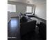 Spacious living room featuring dark wood-look floors and a comfy sofa at 6245 W Southgate St, Phoenix, AZ 85043