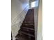 Modern dark wood stairs with a simple white handrail and recessed lighting at 6245 W Southgate St, Phoenix, AZ 85043
