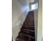 Modern dark wood stairs with a simple white handrail and recessed lighting at 6245 W Southgate St, Phoenix, AZ 85043