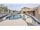 Desert home featuring a beautiful pool with rock landscaping and an outdoor kitchen at 18315 W Santa Alberta Ln, Goodyear, AZ 85338