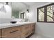 Bathroom with a vanity that features wood drawers, white countertop, and a view to the outside at 6901 E Restin Rd, Carefree, AZ 85377