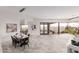 Dining area with modern lighting, stone floors, and views to desert landscaping and outdoor pool at 6901 E Restin Rd, Carefree, AZ 85377