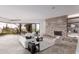 Bright living room with stone fireplace, floor-to-ceiling windows showcasing desert landscaping, and neutral furnishings at 6901 E Restin Rd, Carefree, AZ 85377