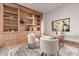 Home office featuring custom built-in bookshelves, neutral accents, and a view to the outdoors at 6901 E Restin Rd, Carefree, AZ 85377