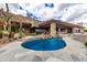 Beautiful pool with rock waterfall features surrounded by desert landscaping and luxurious stone patio at 6901 E Restin Rd, Carefree, AZ 85377