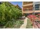 Inviting courtyard with lush greenery, stone pathway, and outdoor seating, adorned with vibrant pink bougainvillea at 7127 E Rancho Vista Dr # 4001, Scottsdale, AZ 85251