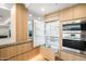 Contemporary kitchen featuring light wood cabinets, stainless steel appliances, and an open refrigerator at 7127 E Rancho Vista Dr # 4001, Scottsdale, AZ 85251