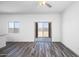 Bright living room featuring a window, sliding glass doors to the backyard, and wood-look flooring at 24636 W St Catherine Ave, Buckeye, AZ 85326