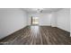 Spacious living room featuring modern flooring, ceiling fan, and sliding glass door access to the yard at 24621 W Alta Vista Rd, Buckeye, AZ 85326