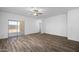 Spacious living room featuring modern flooring, ceiling fan, and sliding glass door access to the yard at 24621 W Alta Vista Rd, Buckeye, AZ 85326