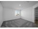 Cozy bedroom with neutral carpet, natural light, and a doorway leading to an ensuite bathroom at 6486 S 246Th Ln, Buckeye, AZ 85326