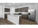 Modern kitchen boasts gray cabinets, stainless steel appliances, granite countertops and central island at 6486 S 246Th Ln, Buckeye, AZ 85326