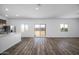 Open-concept living area with wood-look flooring, views to the kitchen, and access to the backyard at 6486 S 246Th Ln, Buckeye, AZ 85326