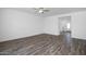 Bright, open-concept living area features stylish gray wood-look flooring and a modern ceiling fan at 6486 S 246Th Ln, Buckeye, AZ 85326