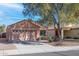 Charming single-story home with a well-manicured front yard and a large tree providing shade at 37108 W Bello Ln, Maricopa, AZ 85138