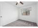 Well-lit bedroom featuring a window, neutral carpeting, and a ceiling fan at 4032 W Reade Ave, Phoenix, AZ 85019