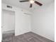 This well-lit bedroom features a ceiling fan, closet with standard doors, and carpeted floors at 4032 W Reade Ave, Phoenix, AZ 85019